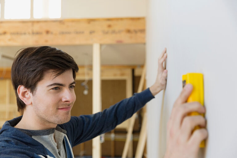 Man using stud finder on wall