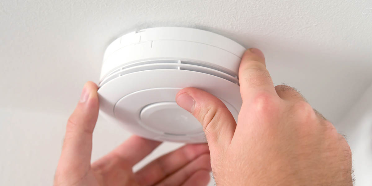 Man installing carbon monoxide detector