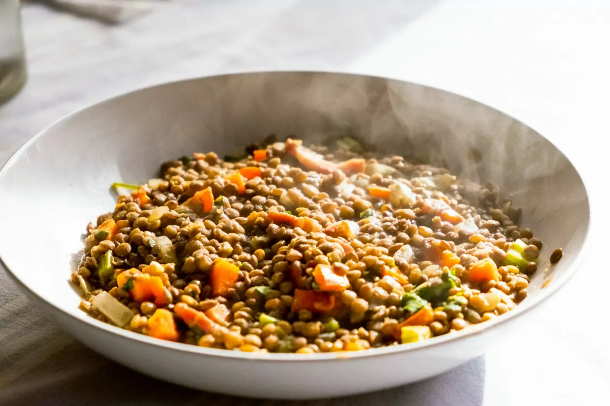 homemade dish of lentils with vegetables and carrots and smoke