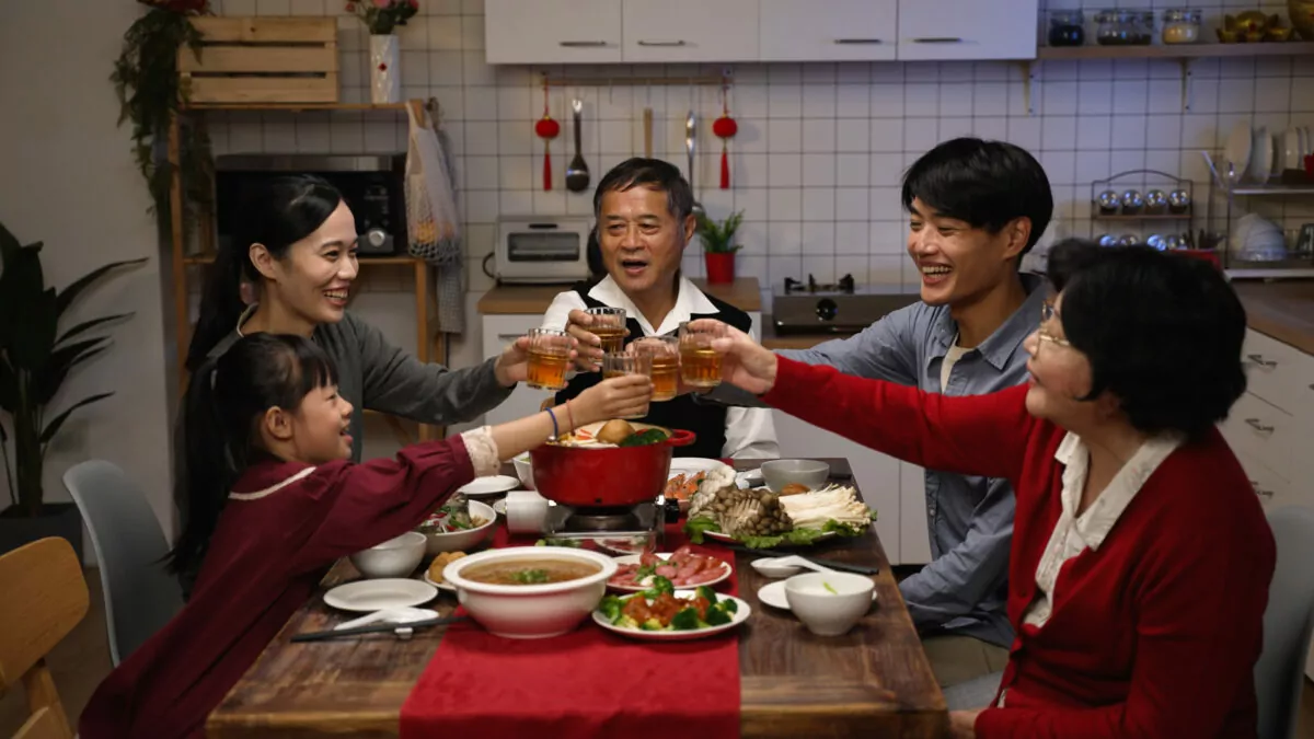 family with mixed generation raising glasses